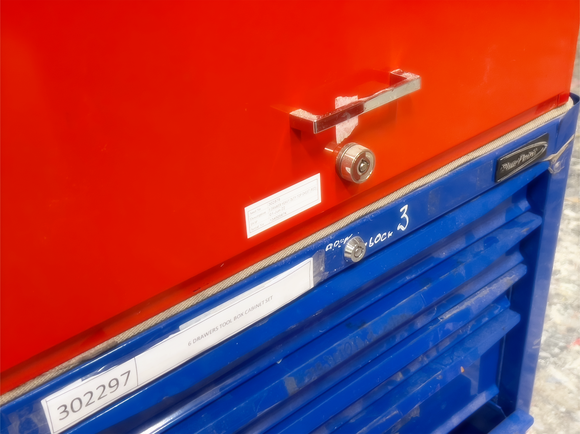 Close-up of a vintage-looking red and blue metal toolbox cabinet with locks, label stickers, and six drawers marked as "6 DRAWERS TOOL BOX CABINET SET".