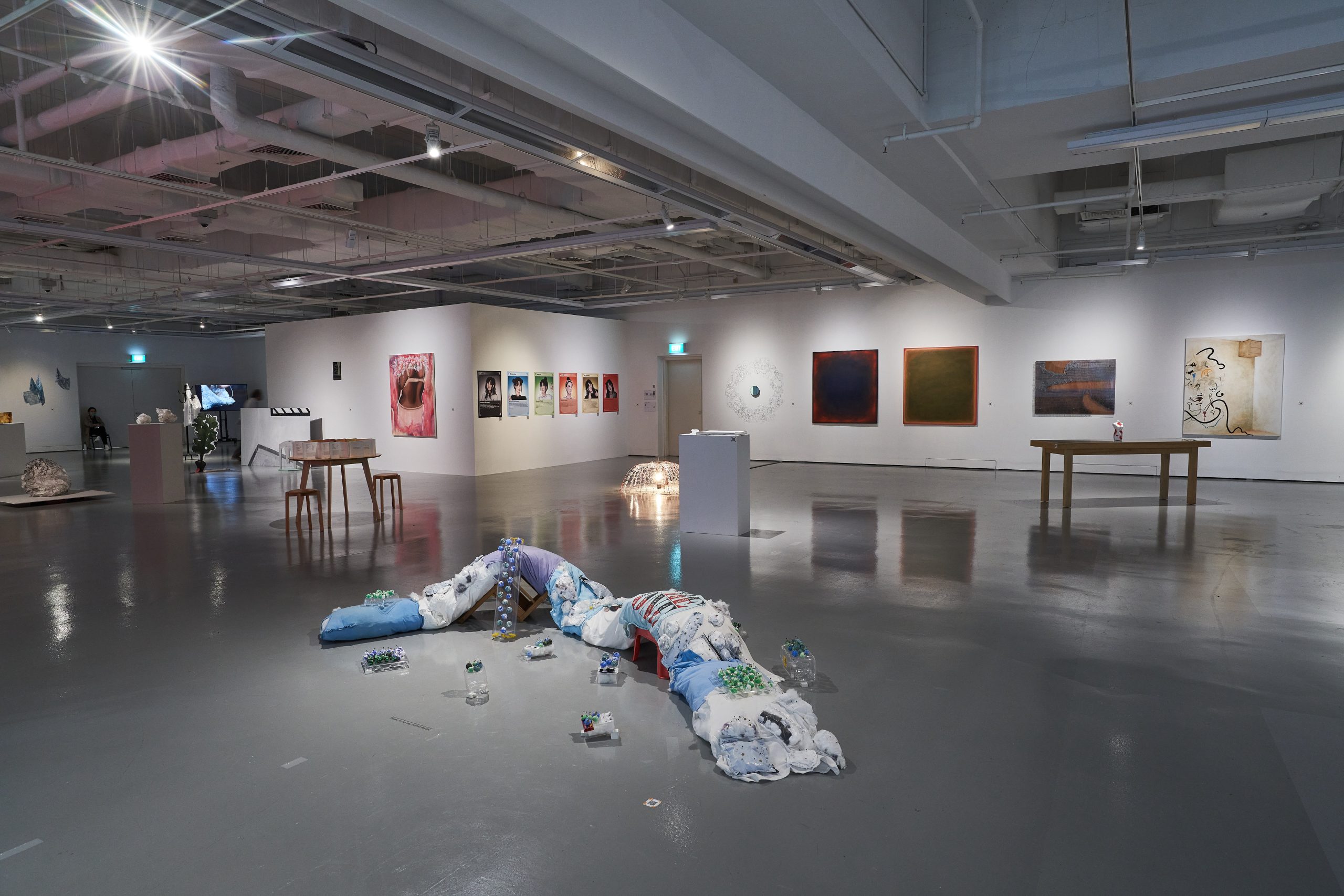 LASALLE gallery with paintings, photography and installations, including a floor sculpture of fabric and plastic bottles in the foreground.