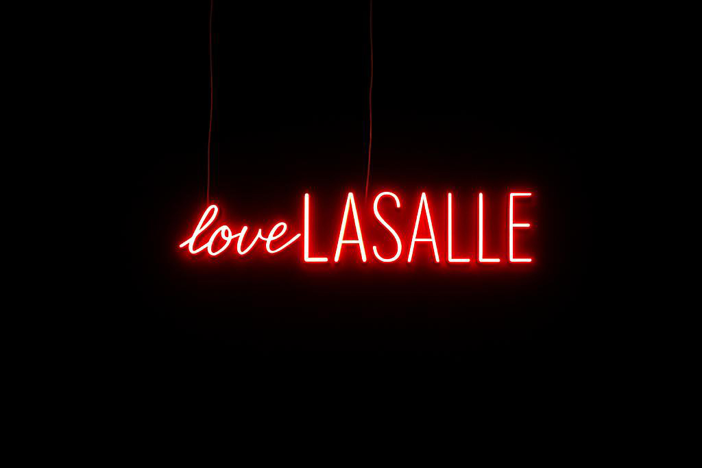 Red neon sign on a black background reading "loveLASALLE" in cursive and block letters.